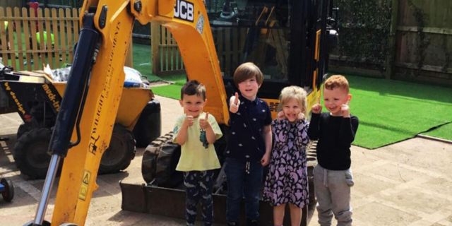 Children enjoying time in the garden with JCB digger