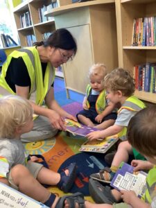 Nursery children at library reading books. 